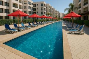 塞得港Unwind in style at Porto Said Chalets by the sea的配有躺椅和遮阳伞的游泳池