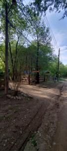 a dirt road with a fence and trees in the background at Cabañas Calimocho in Santa Rosa de Calamuchita