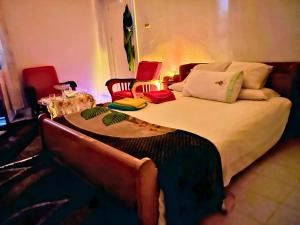 a bedroom with a large bed with two chairs at Gadou Rooms -Private & Shared Stays in Port Said Best Location in Port Said