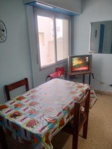 ein Zimmer mit einem Tisch und einem Fernseher und einem Tisch und einem Fenster in der Unterkunft Departamento zona microcentro in Mar del Plata