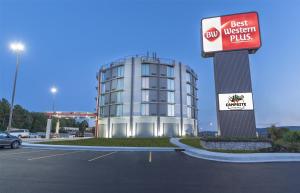 Un edificio en un estacionamiento con un cartel de Best Western Plus en Best Western Plus Wausau Tower Inn, en Wausau