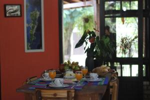 a dining room table with a bowl of fruit and juice at Venere - Bed and Breakfast in Florianópolis