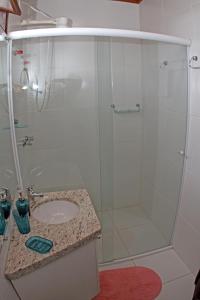 a bathroom with a glass shower with a sink at Venere - Bed and Breakfast in Florianópolis