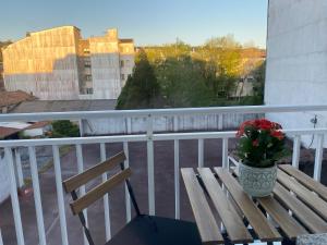 a wooden bench on a balcony with a vase of flowers at A dos Pasos in Caldas de Reis