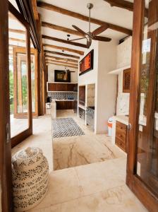 a living room with a ceiling fan and a room with a table at Kasa UhMay Tulum in Francisco Uh May