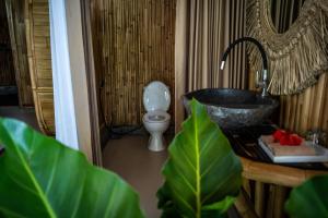 un bagno con lavandino, WC e vasca di Eco Bamboo Island Bali - Bamboo House #2 a Selat Altre 17 foto