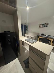 a kitchen with a black refrigerator and a living room at Alojamientosvillamaria in Villa María