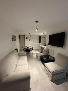 a living room with a white couch and a table at Alojamientosvillamaria in Villa María +8 photos