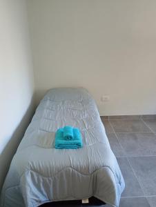 ein Bett mit einem blauen Handtuch darüber in der Unterkunft Departamento in Trenque Lauquen + 16 Fotos