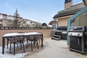 a patio with a table and chairs and a stove at Chic 3 Bedroom Beaver Creek Lodge Residence in Beaver Creek