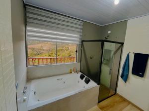 une salle de bain avec une baignoire et une fenêtre dans l'établissement Chalé Vista Linda, à Campos do Jordão 47 autres photos