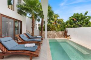 a swimming pool with two chairs and a swimming pool at Villa Jungle, Isla Mujeres in Isla Mujeres