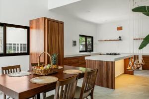 a kitchen with a wooden table and a kitchen with a counter at Villa Jungle, Isla Mujeres in Isla Mujeres