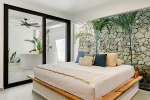 a bedroom with a bed with a stone wall at Villa Jungle, Isla Mujeres in Isla Mujeres +41 photos