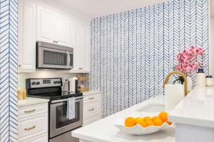 a kitchen with a bowl of oranges on a counter at Designer condo w oceanfront & walk to Worth Ave in Palm Beach