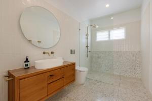 a bathroom with a sink and a mirror and a toilet at Sunnyside On Burns - Central,Farmers Market, Beach in Byron Bay +7 photos