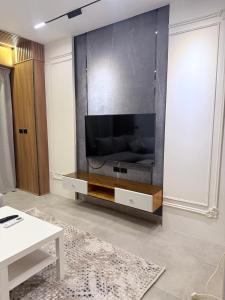 a living room with a large flat screen tv on a wall at madintay b8 modern cozy studio in Madinaty