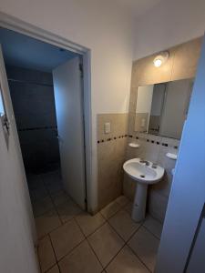 a bathroom with a sink and a shower and a mirror at Alojamientos Vm in Villa María +2 photos