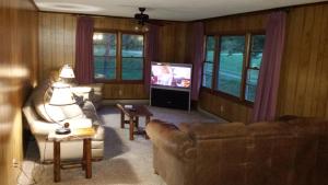 a living room with two couches and a television at Two Rivers Lodge in Bryson City