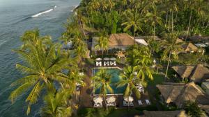 an aerial view of a resort with palm trees and the ocean at Nirwana Beach & Resort in Candidasa
