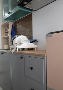 a kitchen counter with some dishes on top of it at Cozy Studio Skylounge Makassar Apartment in Manda