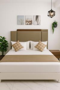 El-ManâkhHoliday Flat by Beach的卧室里有一张大床，配有白色枕头 更多36张照片