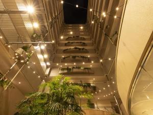 a staircase in a building with lights and plants at Tokyu Stay Yotsuya - Shinjuku Area in Tokyo