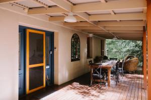 a dining room with a table and chairs on a patio at Toorongo Valley Estate in Noojee
