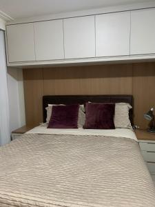 a bedroom with a large bed with white cabinets at Maravilhoso apartamento Beira-mar praia da cachoeira Florianópolis in Florianópolis