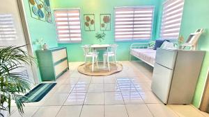 a room with a bed and a table and a couch at Enchanted Home - Near Enchanted Kingdom in Santa Rosa