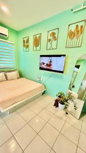 a bedroom with a bed and a flat screen tv on the wall at Enchanted Home - Near Enchanted Kingdom in Santa Rosa