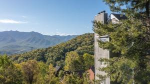 una casa en una colina con montañas al fondo en Romantic Exclusive Condo Stunning Mountain View, en Gatlinburg