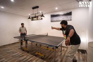 zwei Männer, die um eine Tischtennisplatte stehen in der Unterkunft StayVista at Alpine Bliss - Home Theatre, Bonfire in Masuri