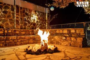 eine Katze, die nachts auf einer Feuerstelle steht in der Unterkunft StayVista at Alpine Bliss - Home Theatre, Bonfire in Masuri + 30 Fotos