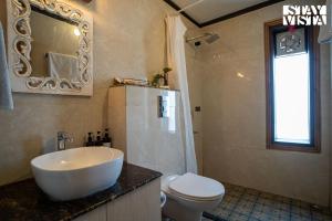 Un baño con lavabo, inodoro y espejo. en StayVista at Alpine Bliss - Home Theatre, Bonfire, en Mussoorie 29 fotos más