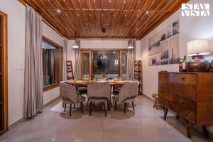 Un comedor con mesa y sillas en StayVista at Alpine Bliss - Home Theatre, Bonfire, en Mussoorie
