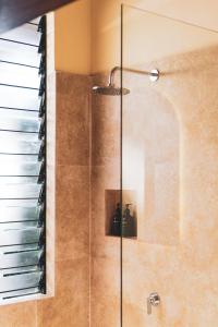 a shower with a glass door in a bathroom at Anchor Bed & Bread in Kuta Lombok +47 photos