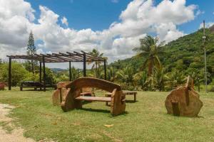 a park with a wooden bench in the grass at Flat Natureza Hotel Fazenda Pedra do Rodeadouro Bonito PE in Bonito