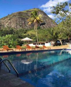 a swimming pool with a mountain in the background at Flat Natureza Hotel Fazenda Pedra do Rodeadouro Bonito PE in Bonito