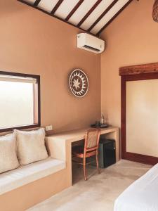 a bedroom with a desk with a chair and a window at Anchor Bed & Bread in Kuta Lombok