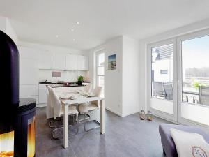 ペーネミュンデにあるFerienhaus am Yachthafen in Peenemuendeのテーブルと椅子のあるキッチンとダイニングルーム