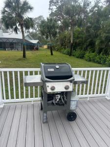 Perfect Getaway-Lovely Cottage House- Near Beaches في نوكوميس: وجود شواية على سطح السفينة بجانب السياج