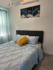 Perfect Getaway-Lovely Cottage House- Near Beaches في نوكوميس: سرير مع اللوح الأمامي الأسود في غرفة النوم