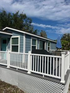 Perfect Getaway-Lovely Cottage House- Near Beaches في نوكوميس: شرفة مع سور أبيض ومنزل