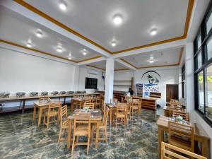 a dining room with wooden tables and chairs at Ocean Star Coron in Coron