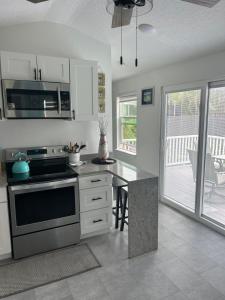 Perfect Getaway-Lovely Cottage House- Near Beaches في نوكوميس: مطبخ مع موقد وطاولة عمل