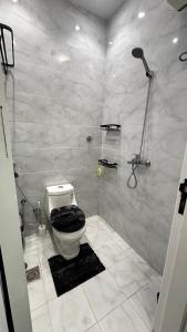 a white bathroom with a shower and a toilet at غرفة نوم وصالة مودرن بدخول ذاتي in Jeddah