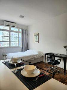 ein weißer Raum mit einem Tisch mit einer Schüssel und Gläsern in der Unterkunft 13 andar, Studio, Centro, vista incrivel Guaíba in Porto Alegre