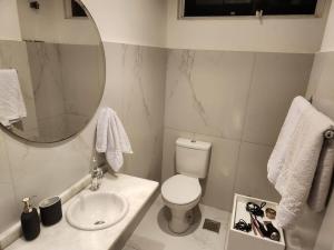 ein Badezimmer mit Toilette, Waschbecken und Spiegel in der Unterkunft 13 andar, Studio, Centro, vista incrivel Guaíba in Porto Alegre + 19 Fotos