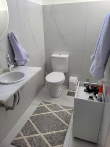 ein weißes Badezimmer mit Toilette und Waschbecken in der Unterkunft 13 andar, Studio, Centro, vista incrivel Guaíba in Porto Alegre